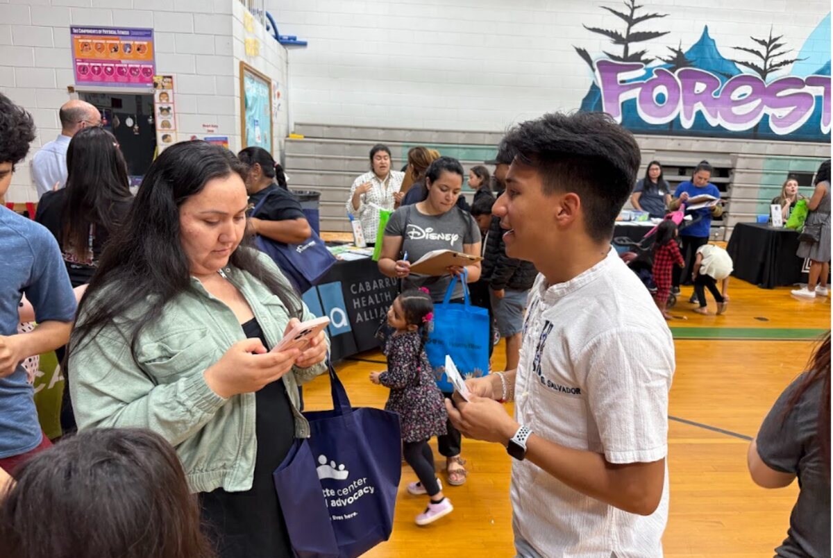 A Camino team member talking with a community member at an outreach event