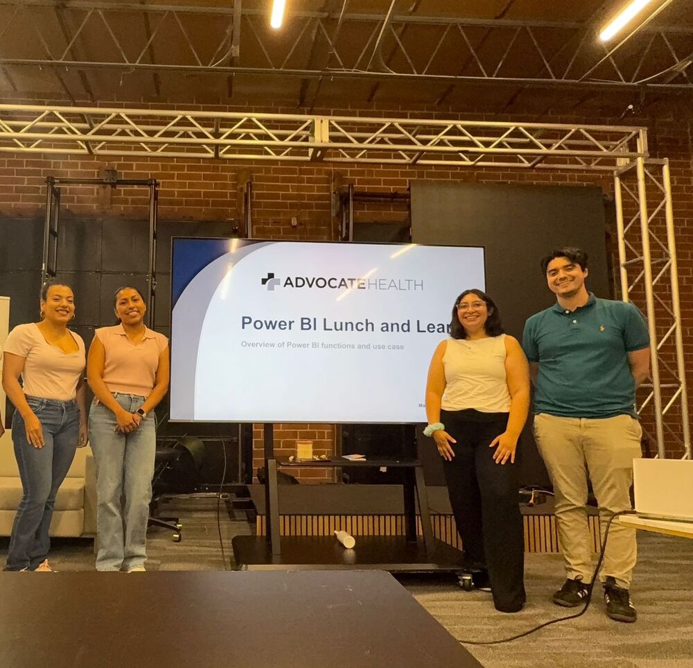 Sarai Ordonez and three members of the CRI team standing in front of the Power BI Lunch and Learn screen